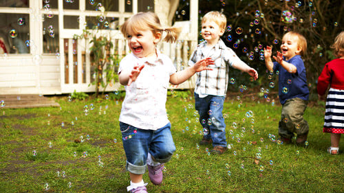Niños pequeños jugando con burbujas
